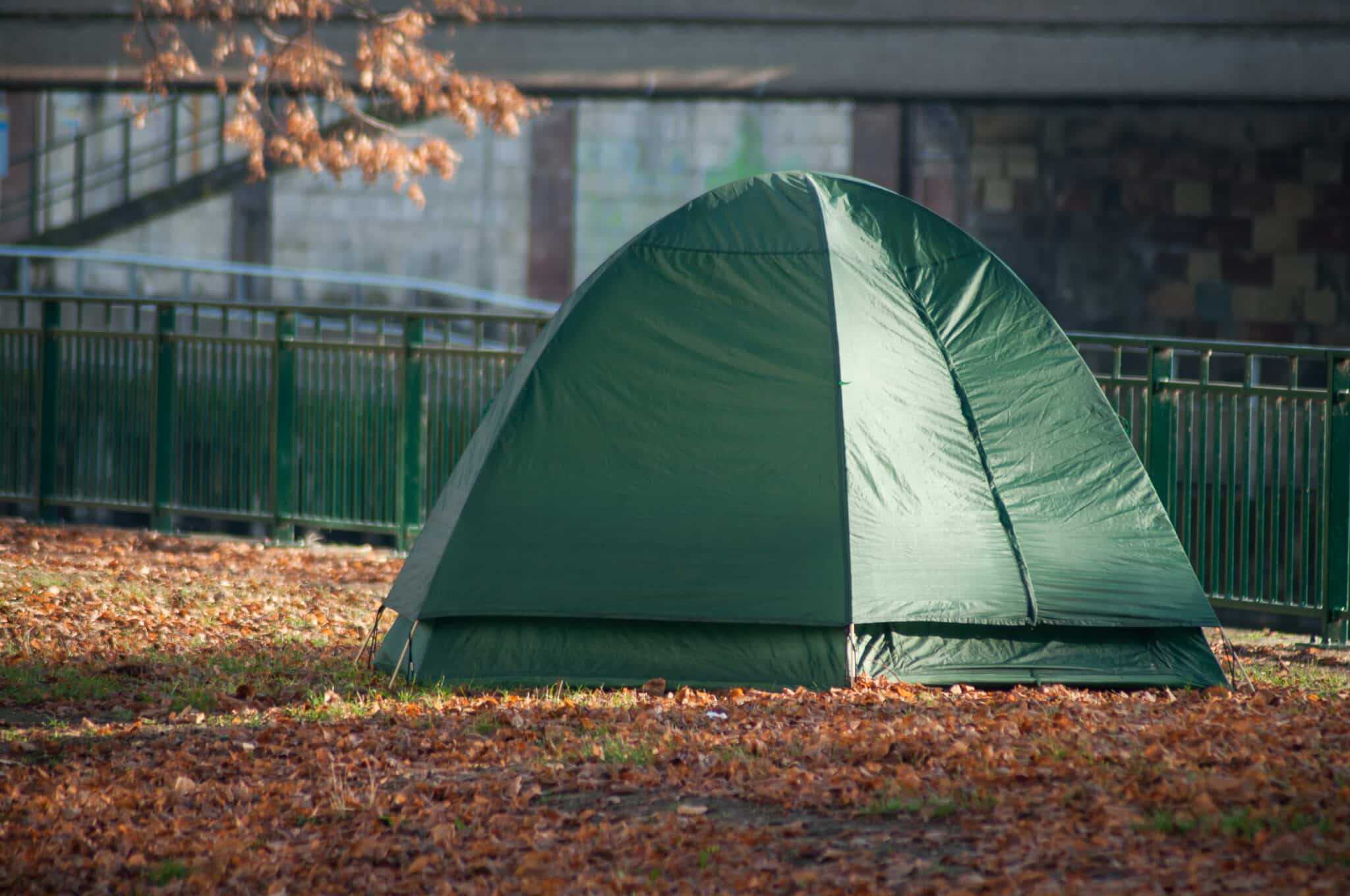 closeup of homeless in igloo tent in urban park